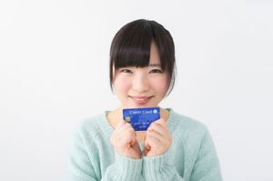 両手でクレジットカードを持つ女性