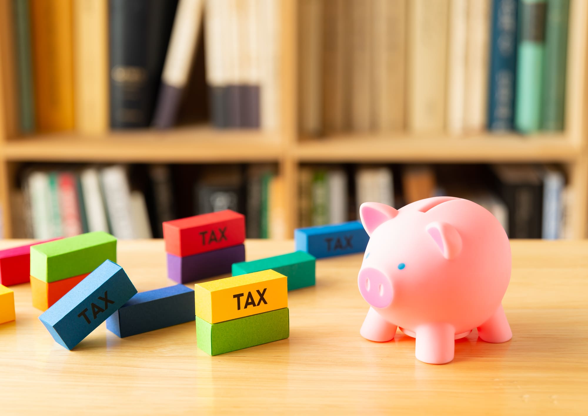 taxと書かれた積み木と豚の貯金箱