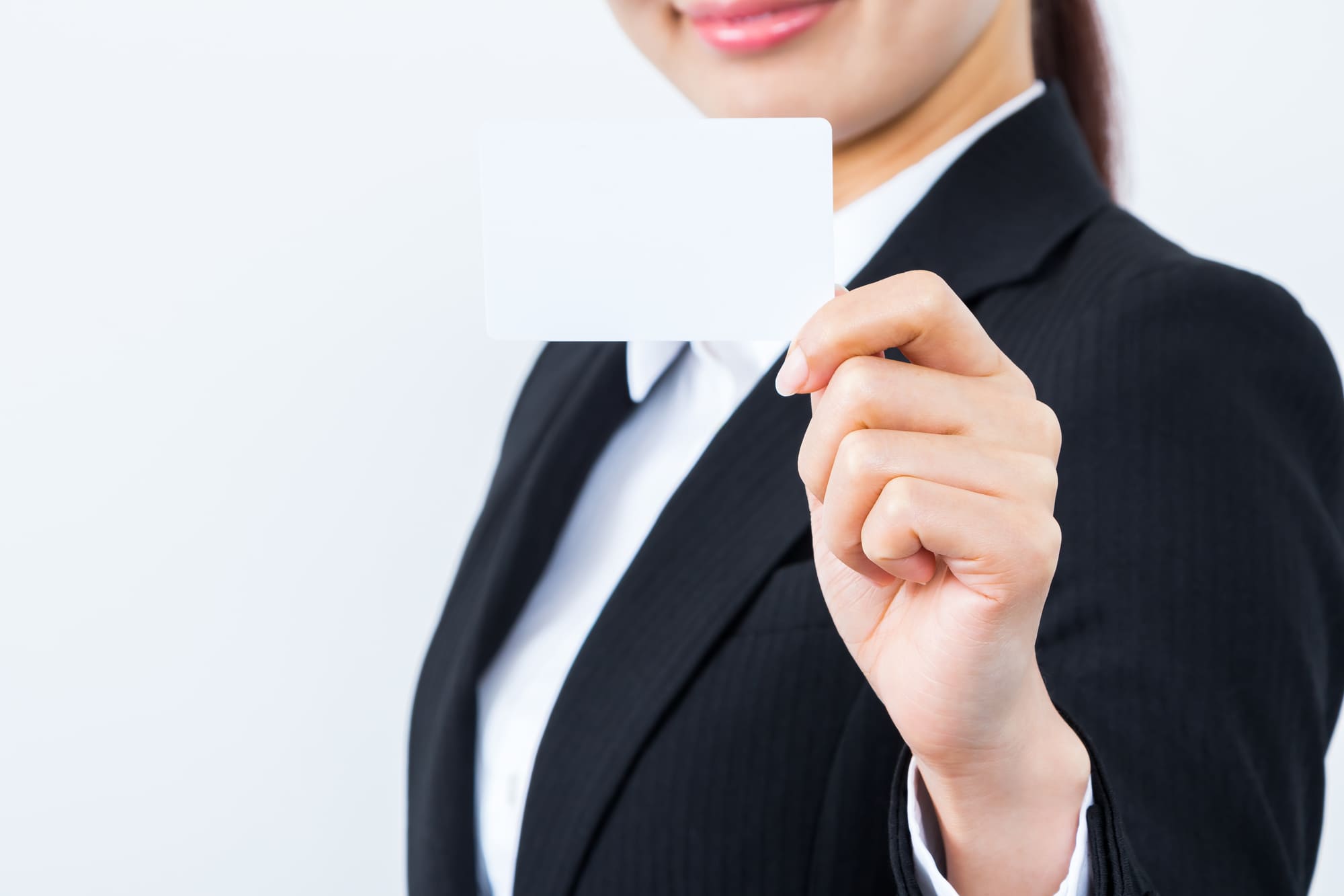 クレジットカードを持つスーツ姿の女性
