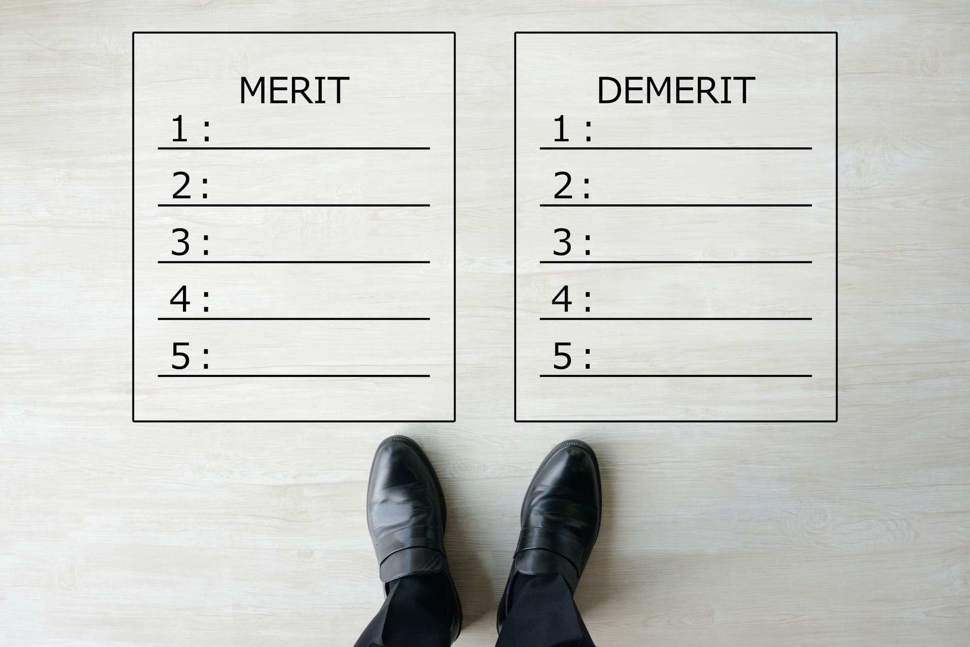 足元に書かれた「MERIT」「DEMERIT」