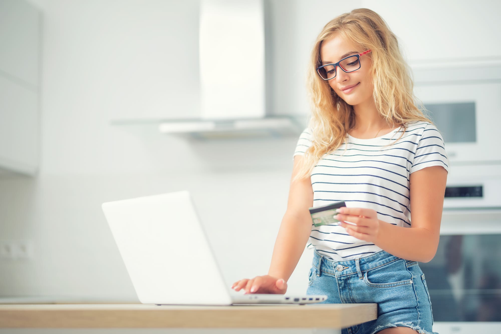 クレジットカードを持っている女性がパソコンを見ている