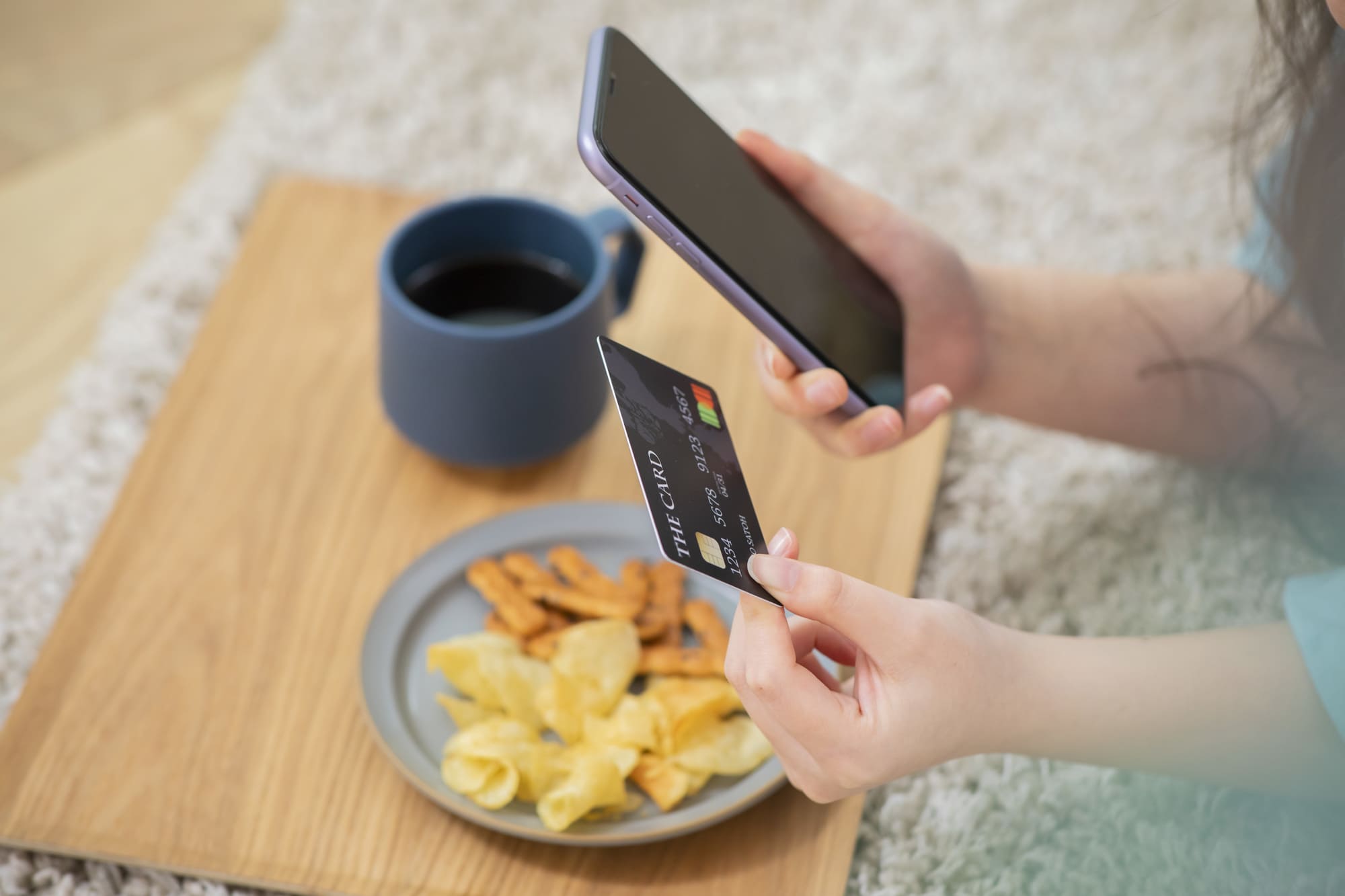スマホでクレジットカードをかざす女性