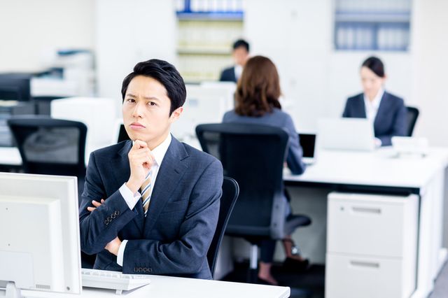 スーツを着た男性が悩んでいる