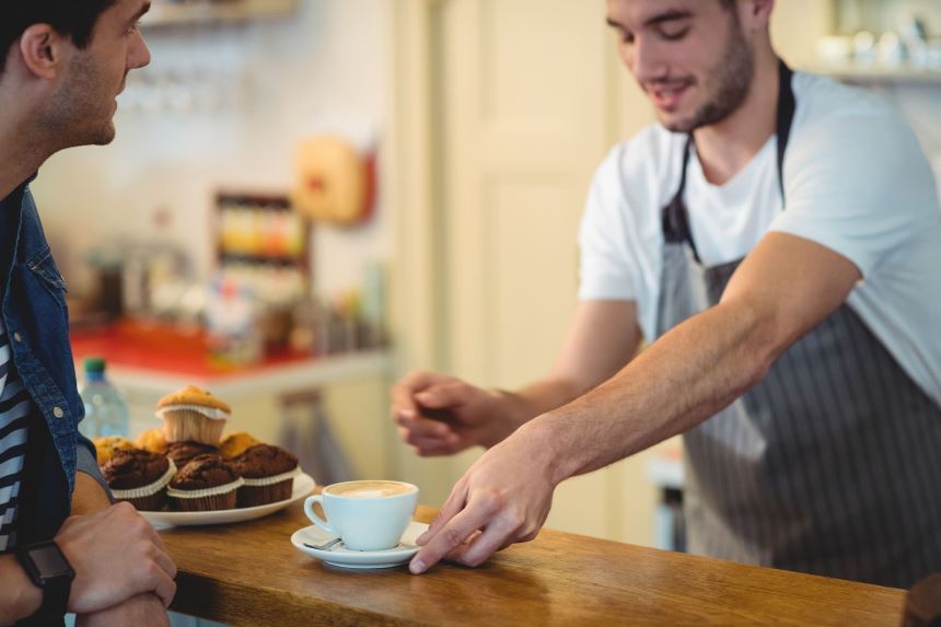 店員からコーヒーを受け取る男性