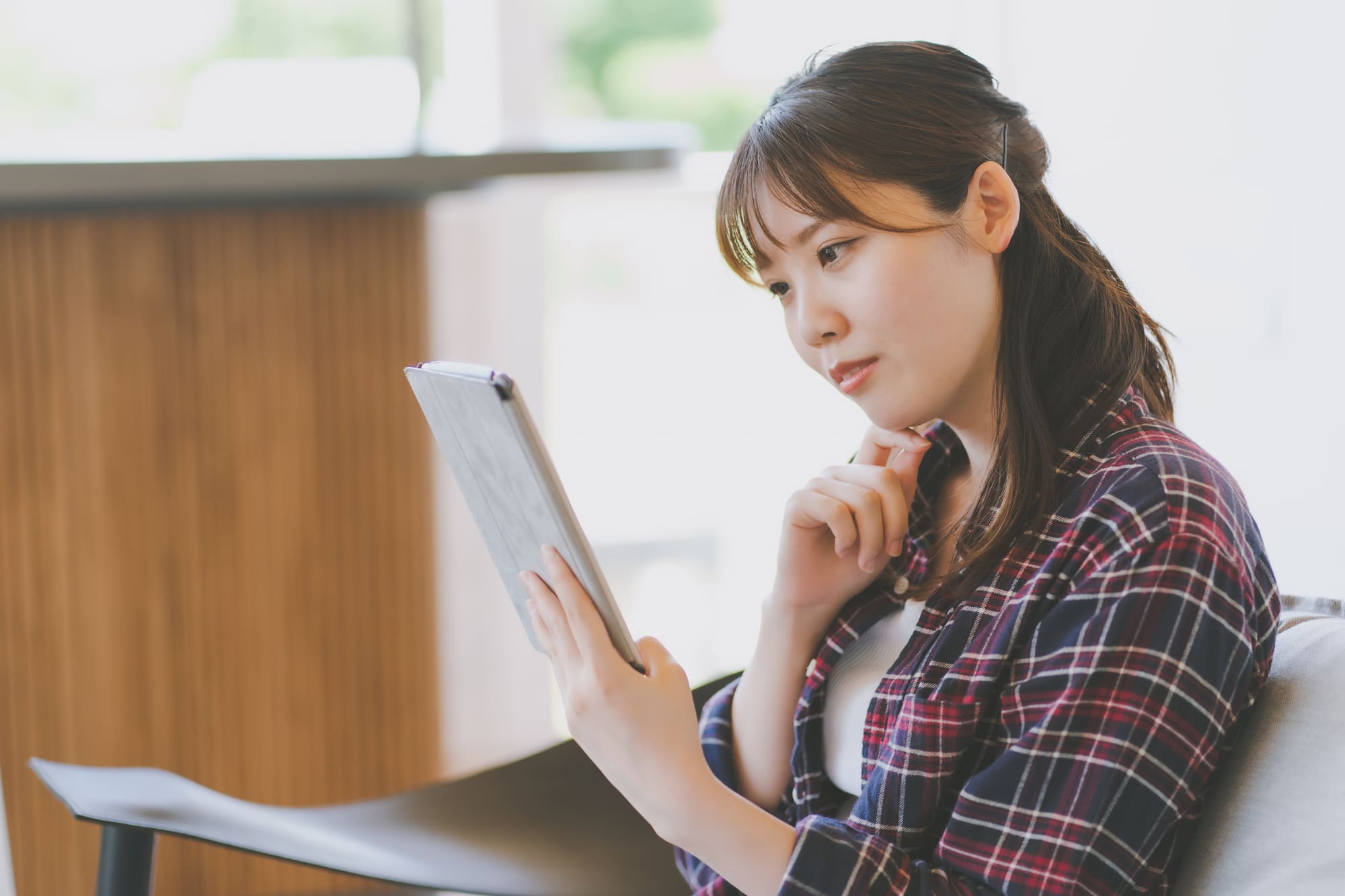 資料を読むチェックのシャツを着た女性