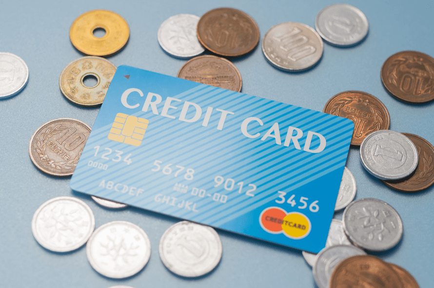 クレジットカードの周りにお金がちらばっている