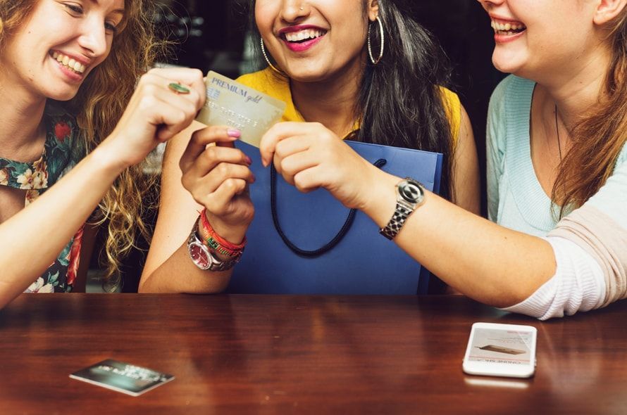クレジットカードを掴む3人の女性