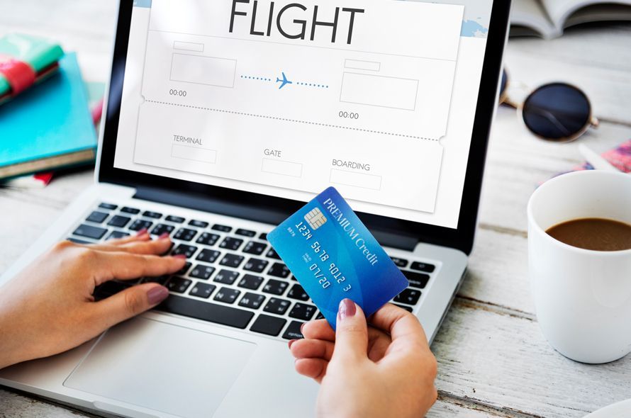 FLIGHTと表示されたパソコンを触りながらカードを持つ人