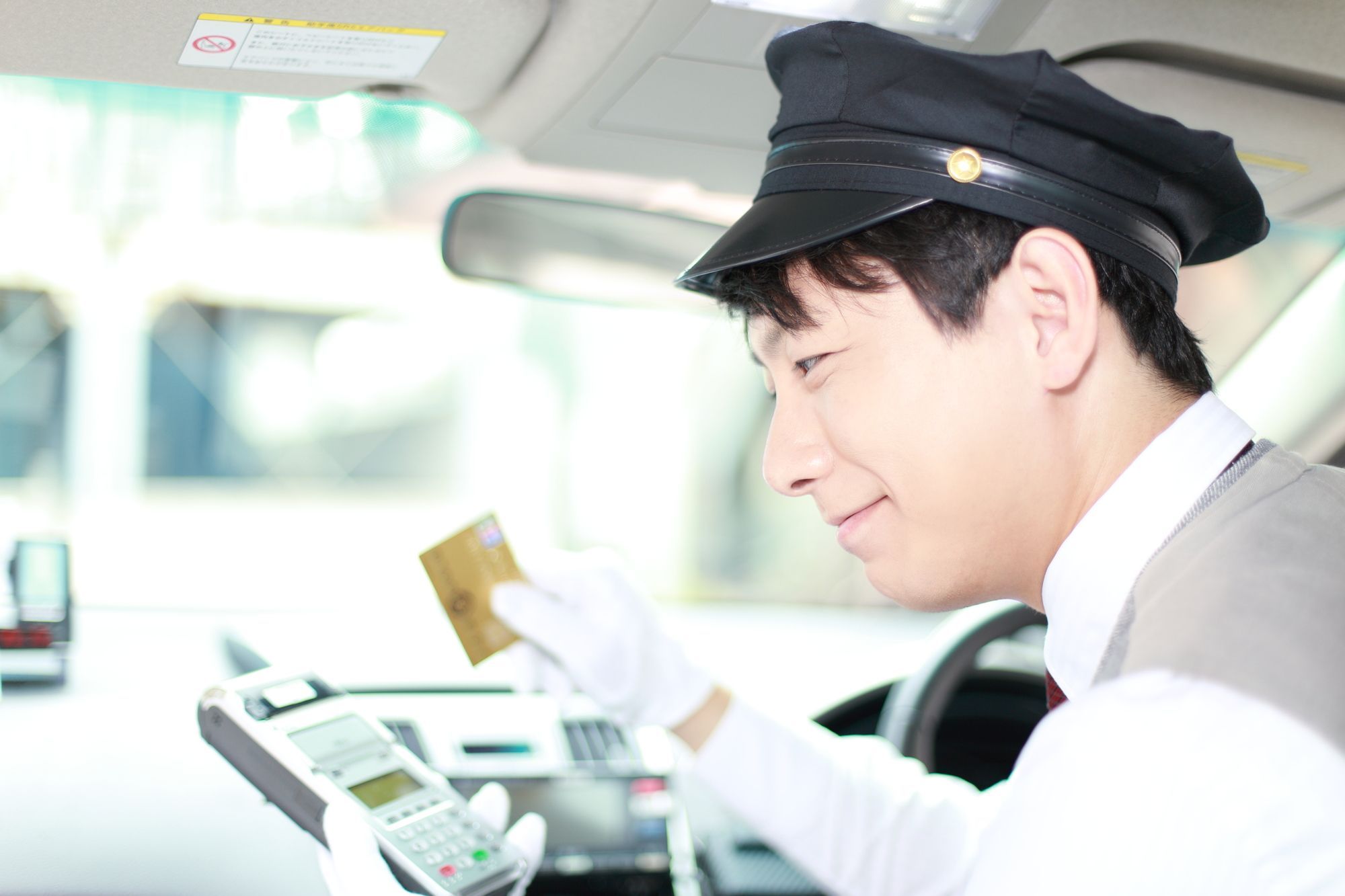 タクシーでカード決済をする男性