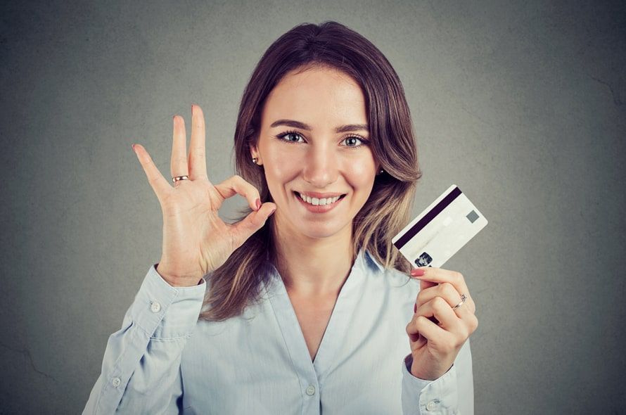 カードを持ちながらOKサインする女性