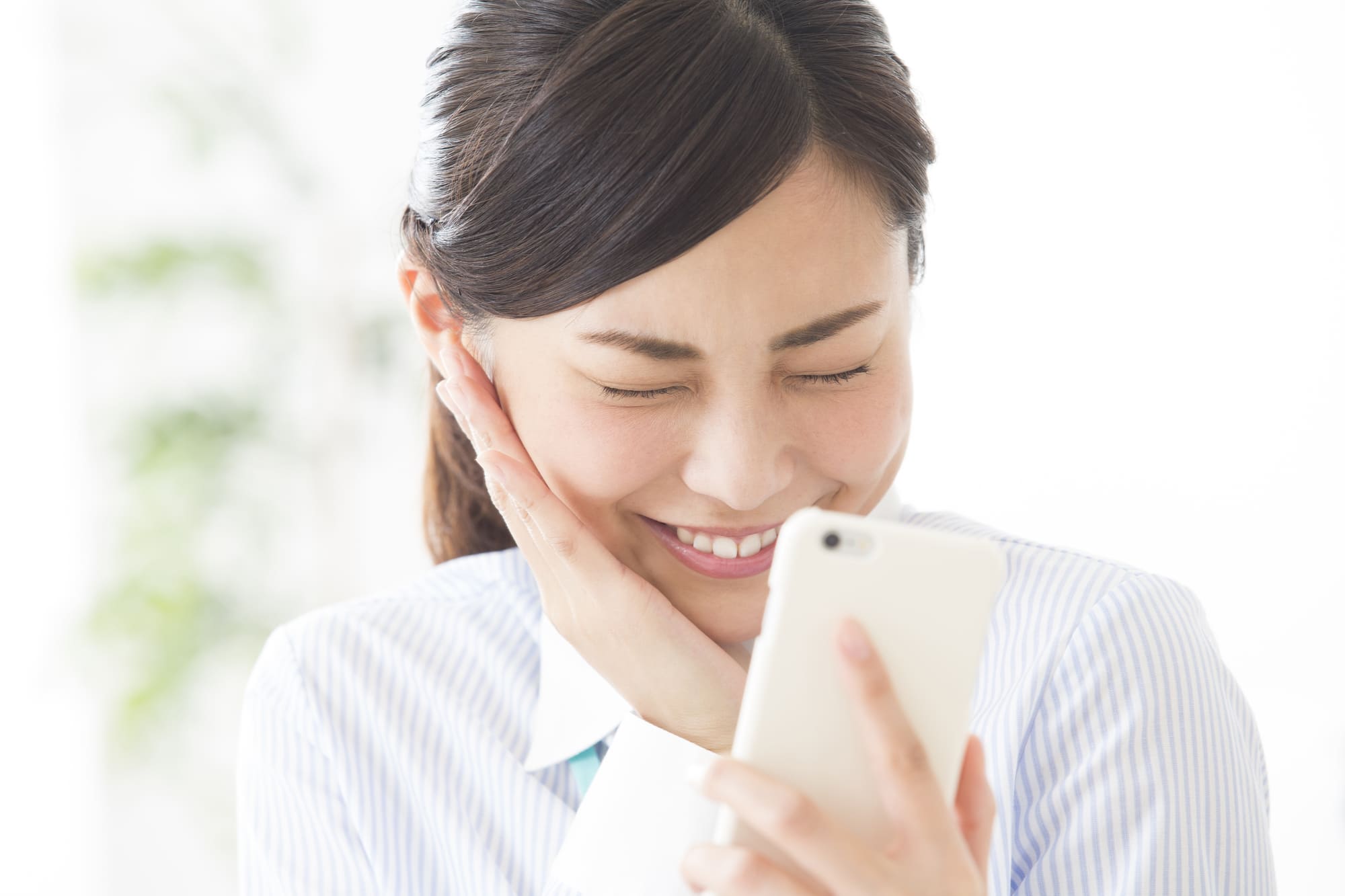 スマホを持ち喜ぶ女性