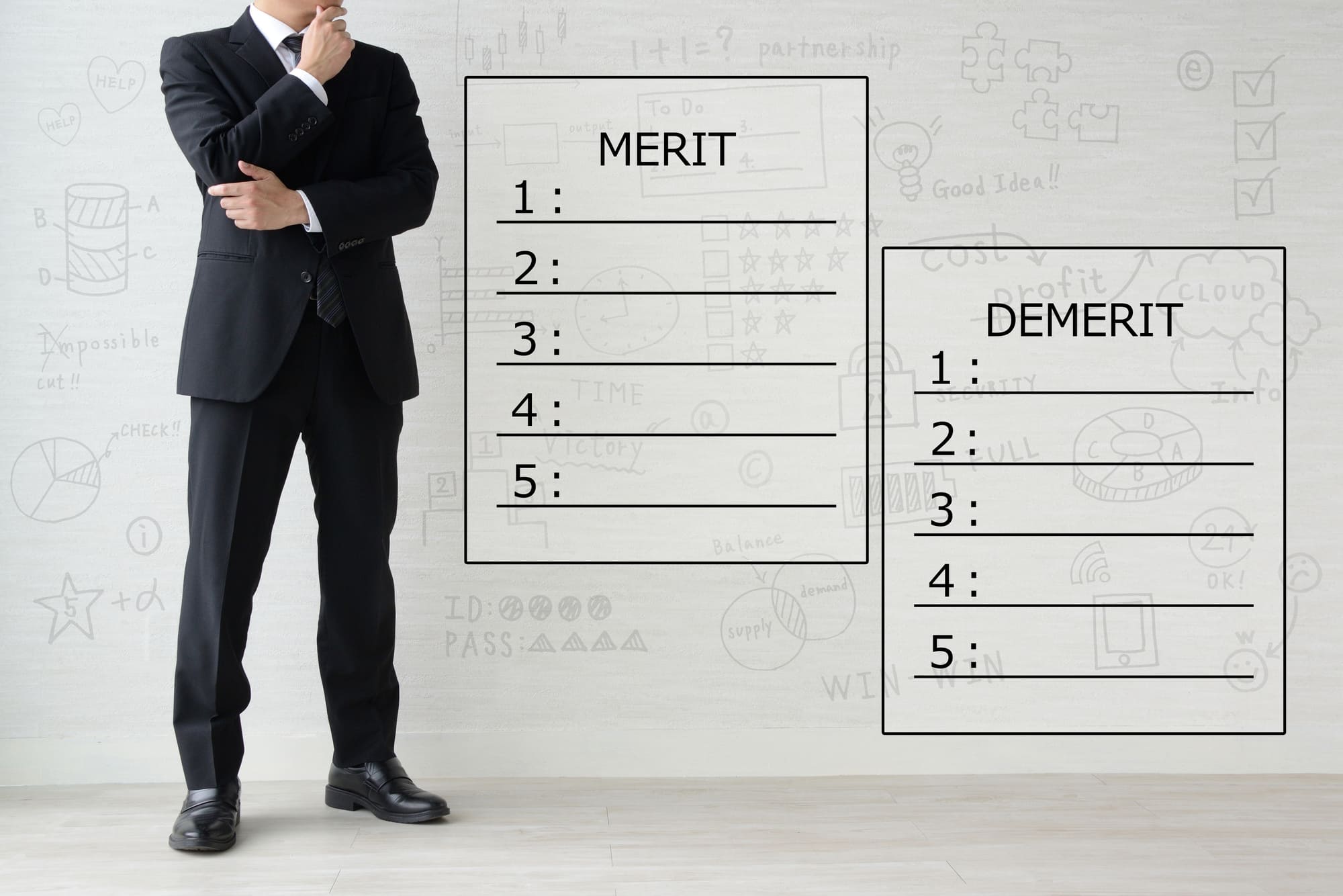meritと demeritと書かれたメモとスーツ姿の男性
