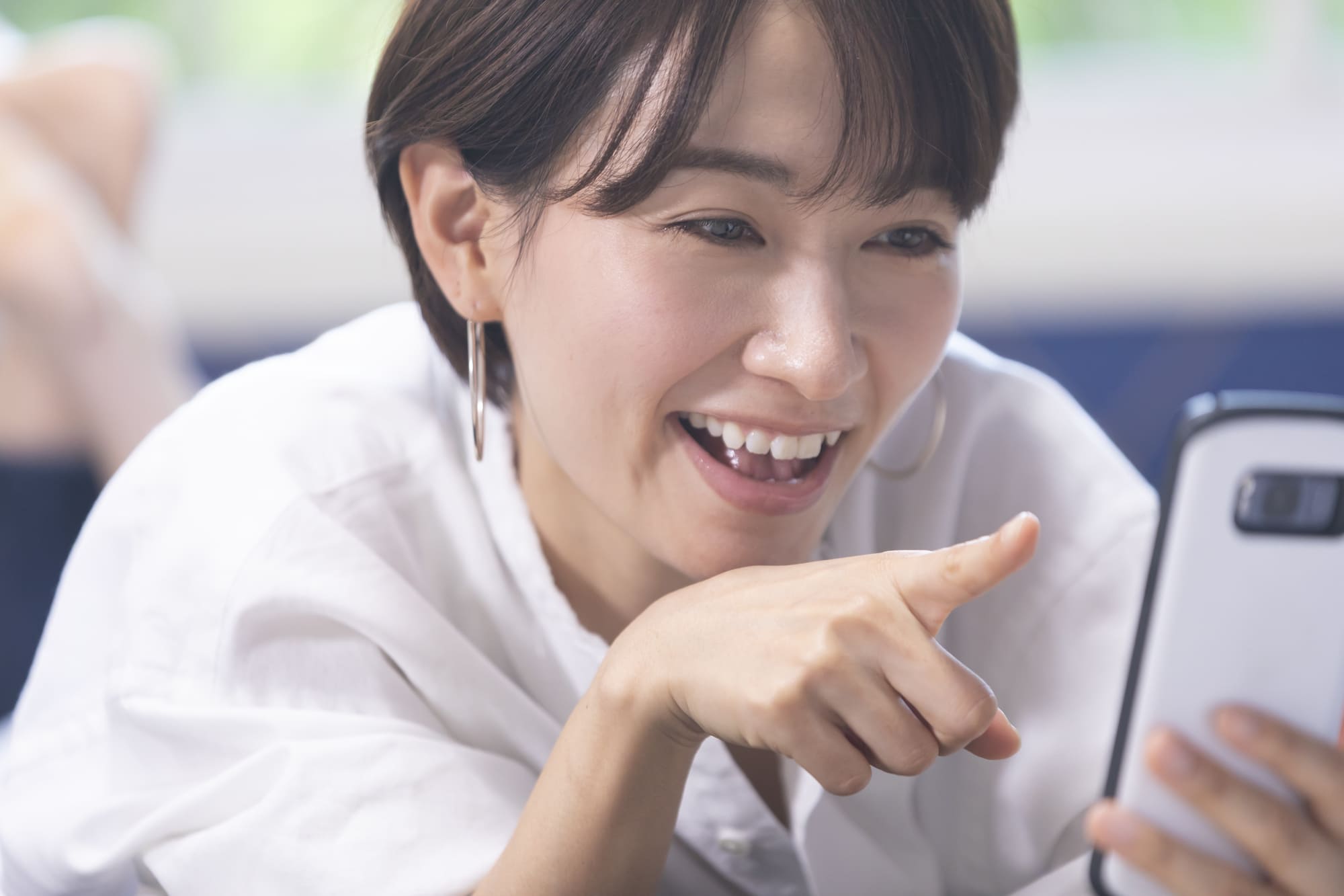 スマホを指差し喜ぶ女性