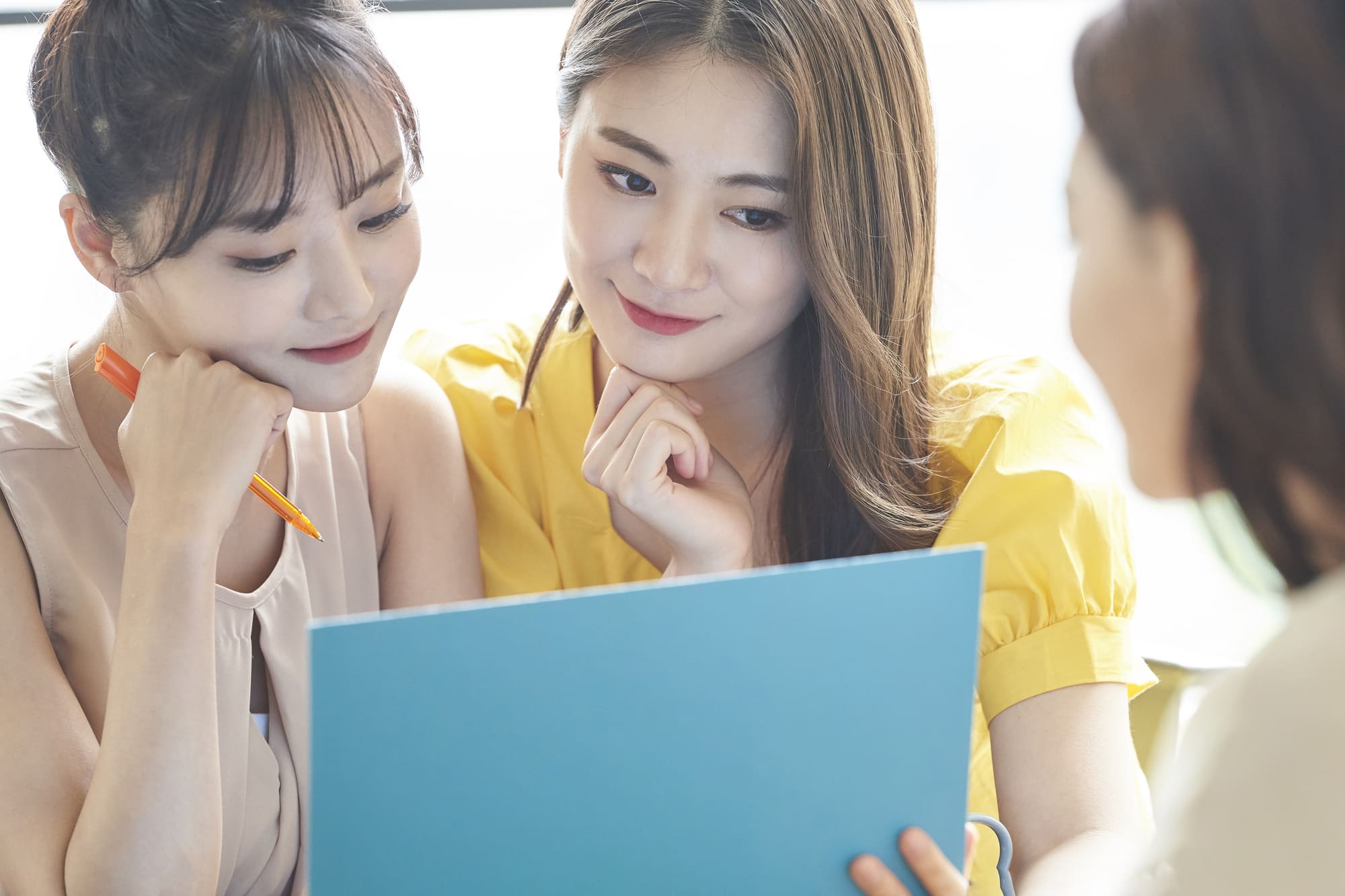 3人の女性が書類を見ている