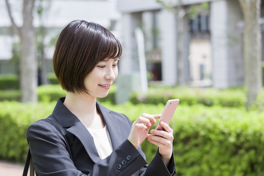 街中でスマホを見る女性