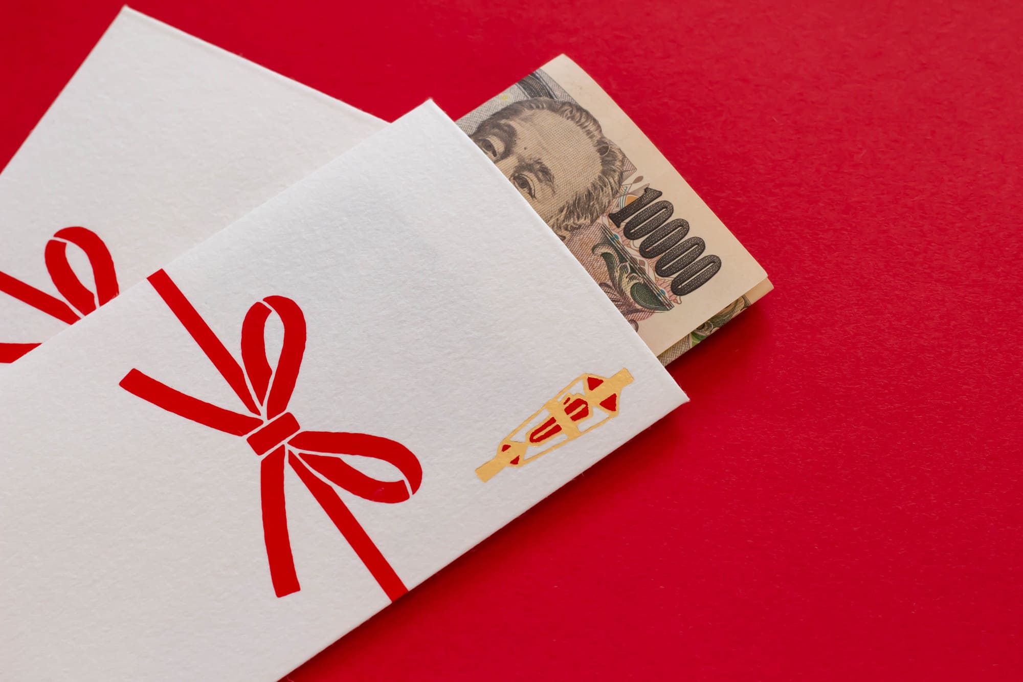 赤の背景に熨斗袋と一万円札