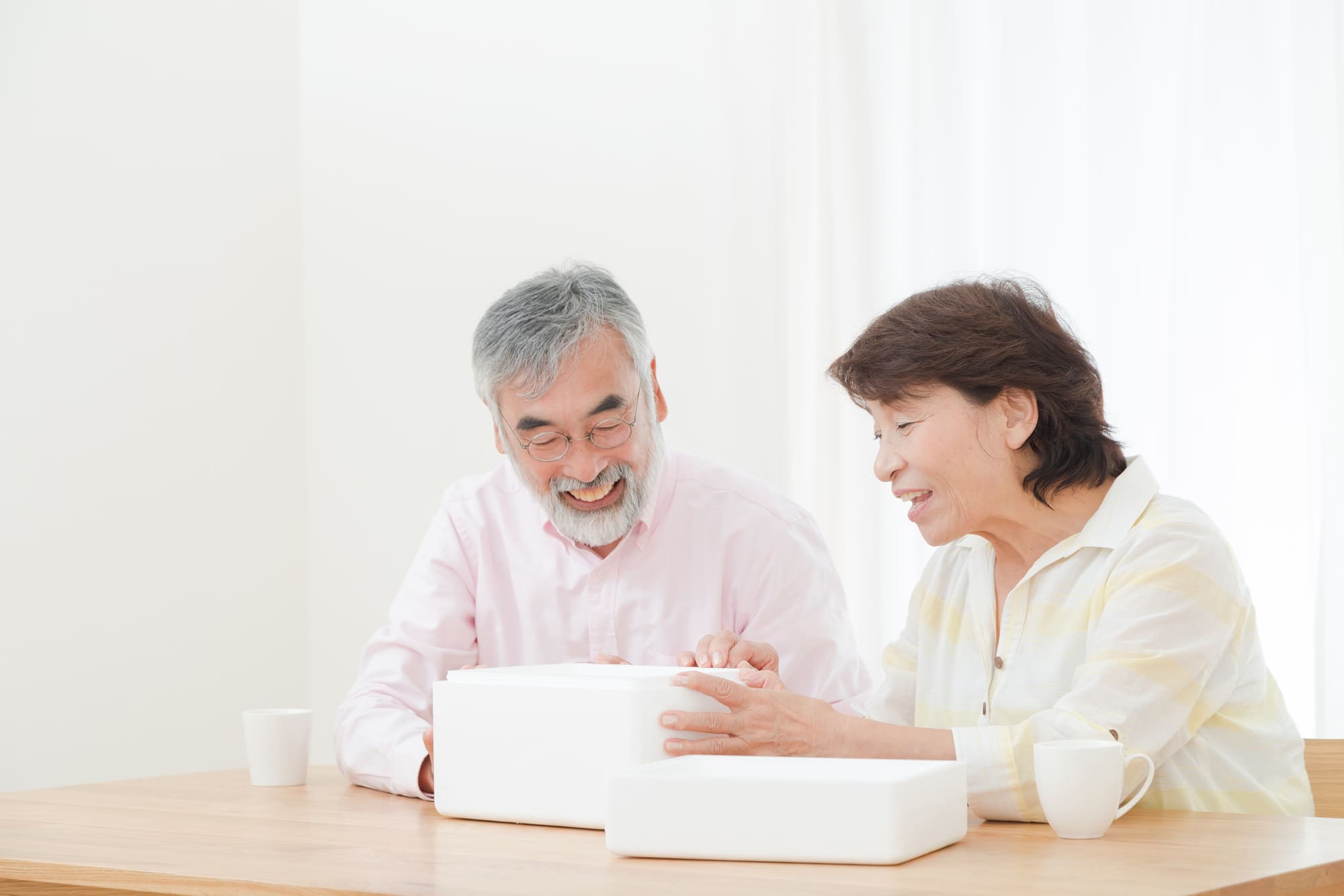白い箱の中を見て喜ぶ老夫婦