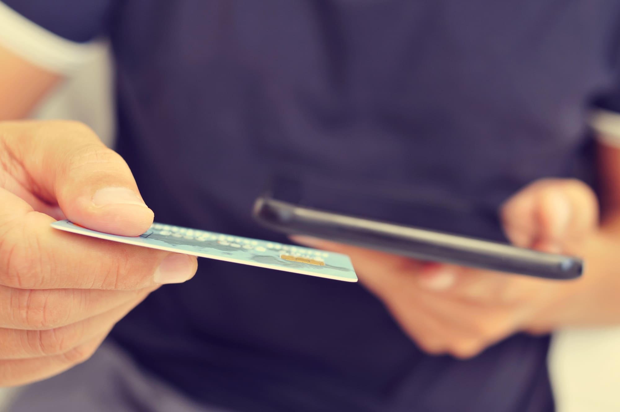 クレジットカードとスマホを持つ男性