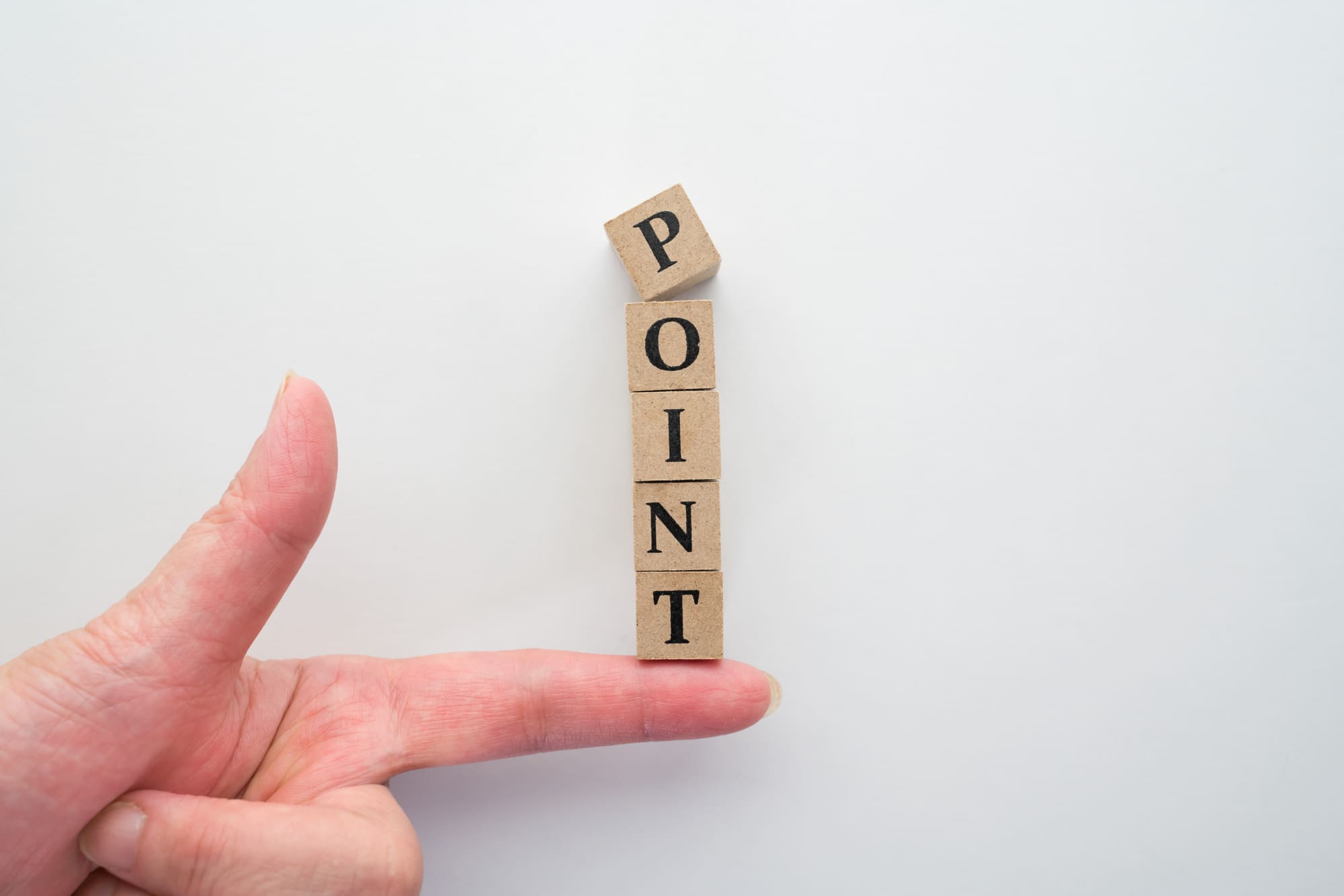 「POINT」が書かれた積み木をのせる人差し指