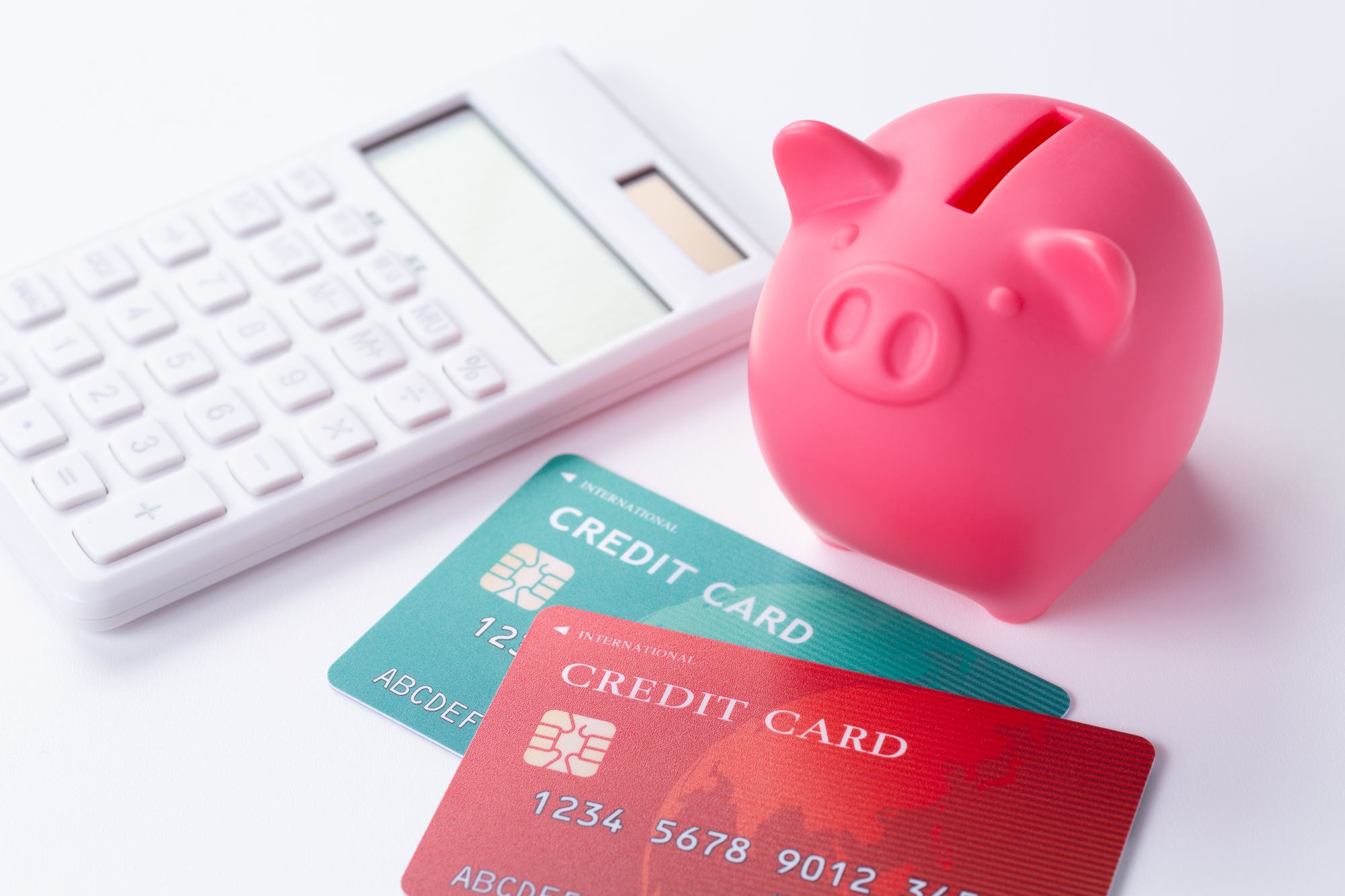 貯金箱とクレジットカードと電卓が置いてある