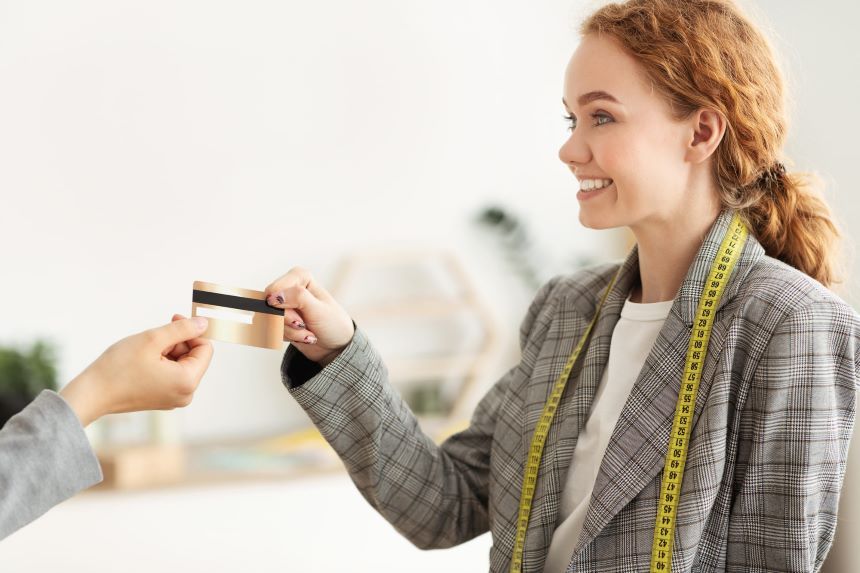 笑顔でクレジットカードを受け取るジャケットを着た女性