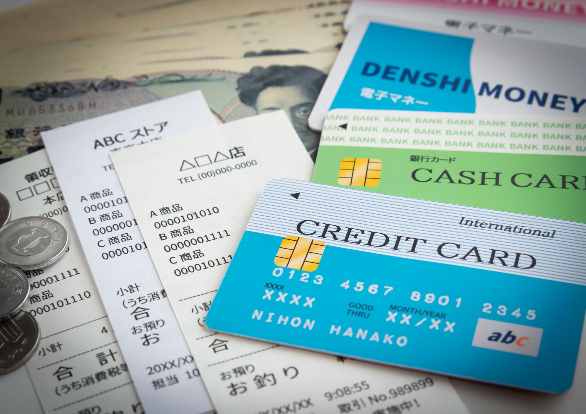 クレジットカードとキャッシュカードとプリペイドカードと現金が置いてある