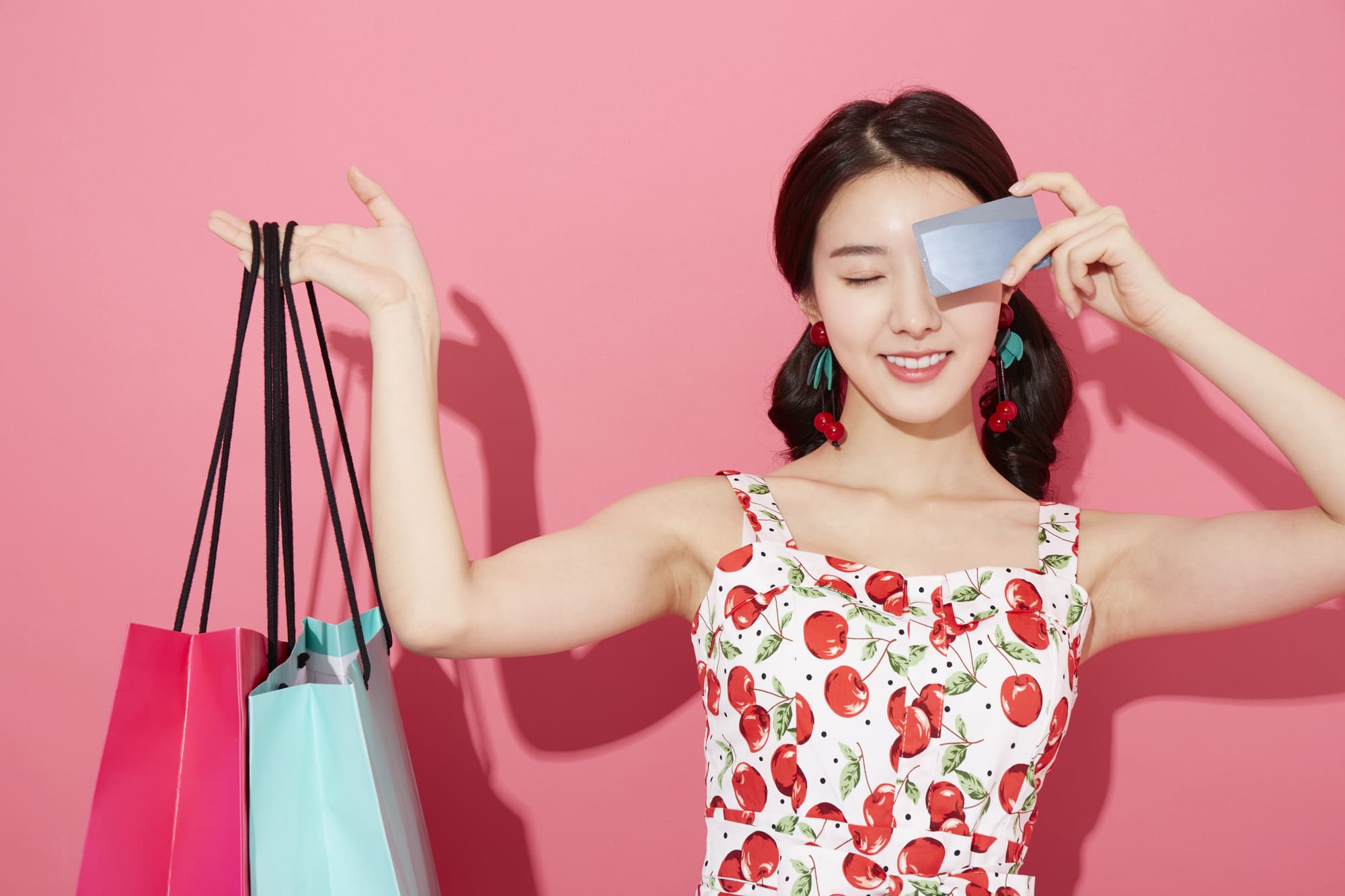 ショッピングバックとクレジットカードを持つ女性